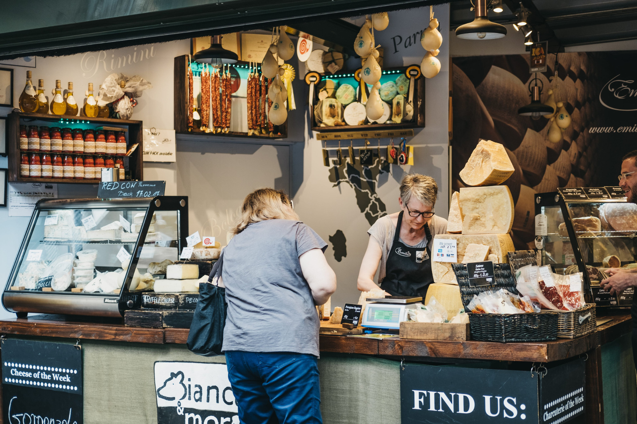 Venditrice e cliente davanti a un banco alimentare di Borough Market.