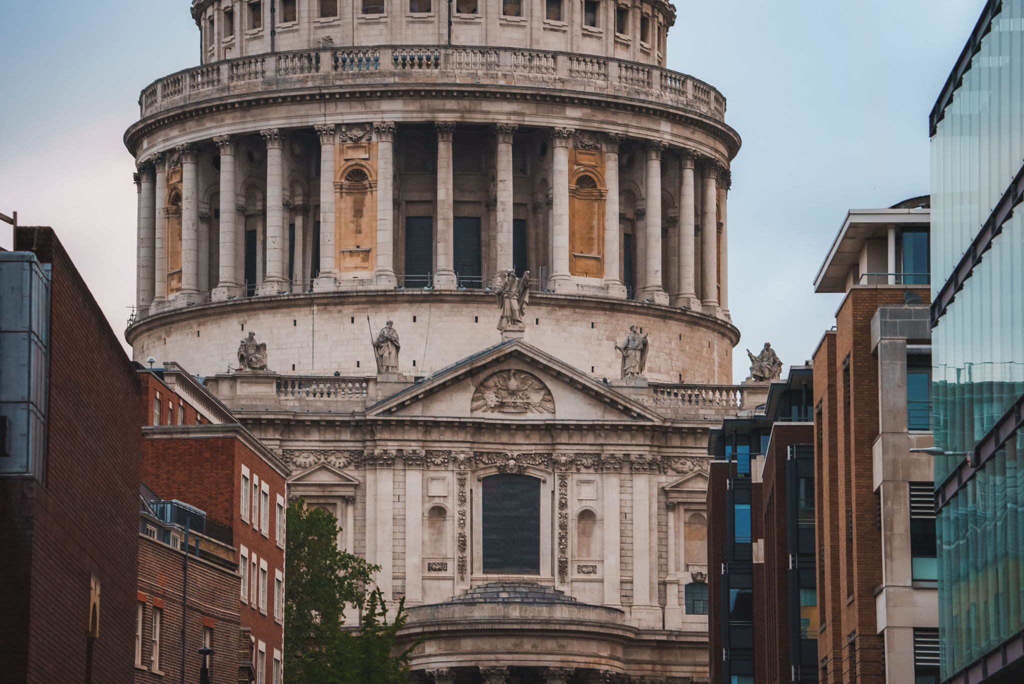 Dettaglio del tamburo della cupola di St Paul’s Cathedral fra edifici in mattoni e vetro.